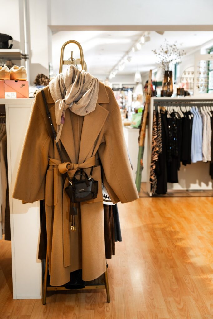 Camel-Mantel mit Schal und kleiner Tasche im Store