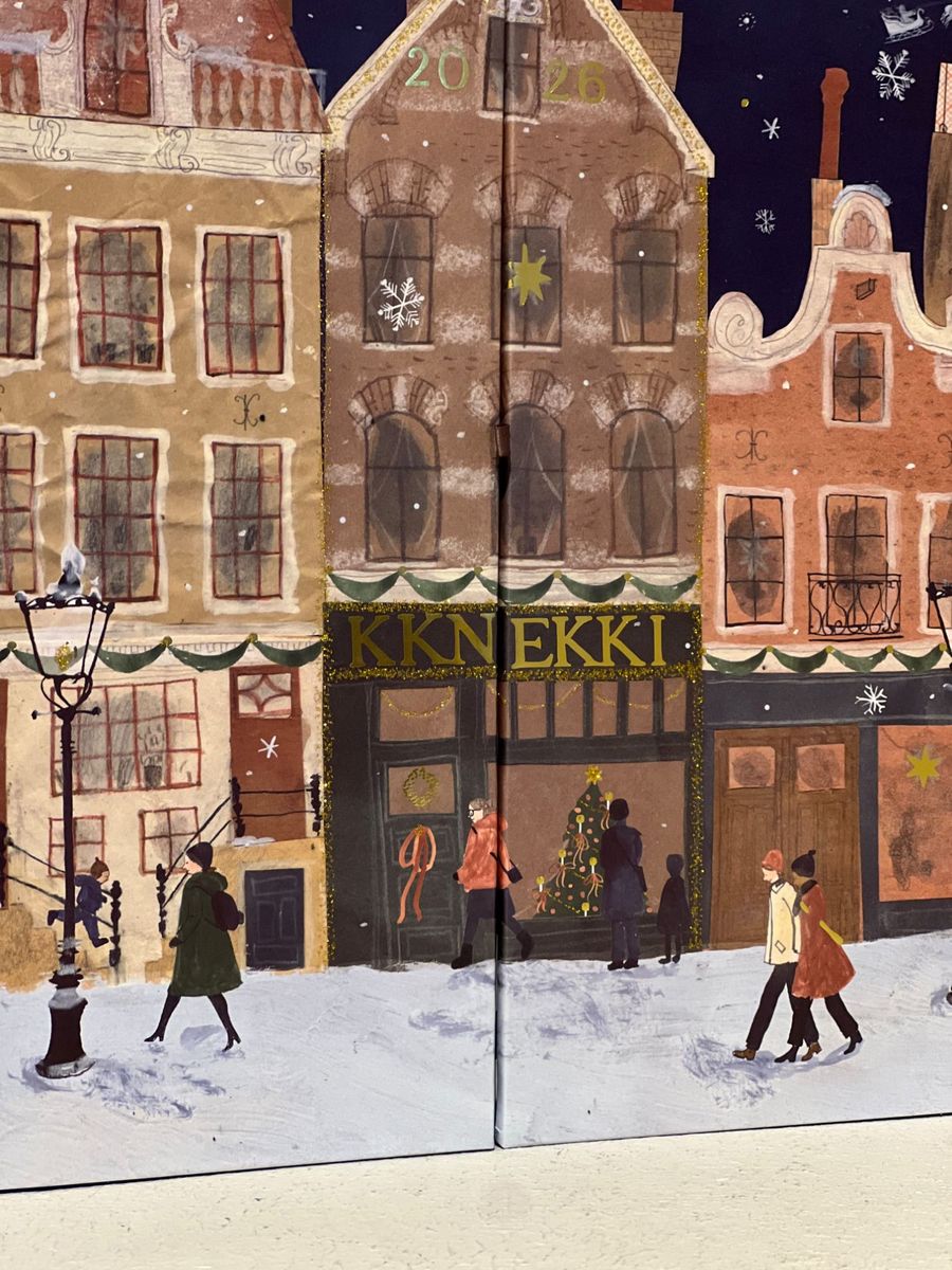 Detail der Vorderseite: illustrierter KKNEKKI Laden mit Weihnachtsbaum im Schaufenster, darüber die Jahreszahl 2026